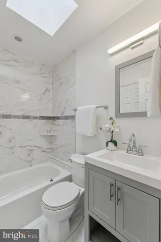 a bathroom with a sink toilet vanity and tub