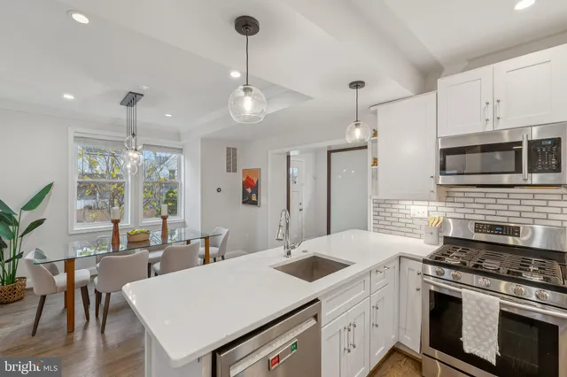 a kitchen with a stove a sink a dining table and chairs