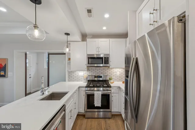 a kitchen with stainless steel appliances granite countertop a refrigerator a sink and a stove