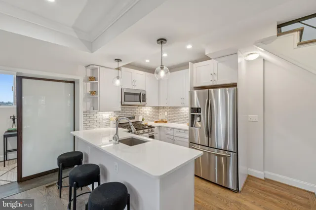 a kitchen with stainless steel appliances a refrigerator sink and cabinets