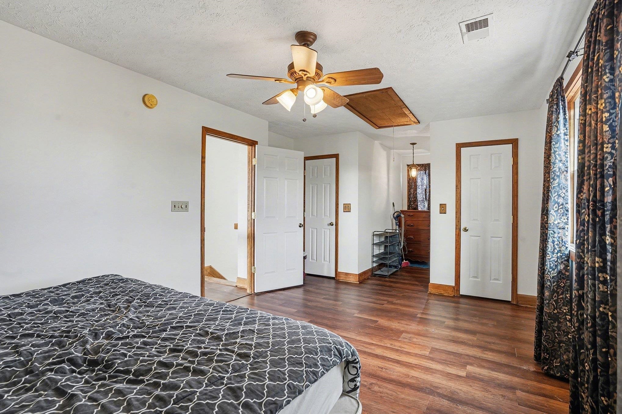 202 Highway 747 Loris Sc 29569 Loris, SC 29569 - Photo 19 of 34 Bedroom featuring attic access, a textured ceiling, dark wood-style flooring, and ceiling fan