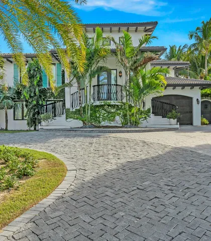 a view of a house with a small yard plants and large tree