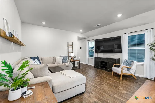 a living room with furniture a flat screen tv and a potted plant