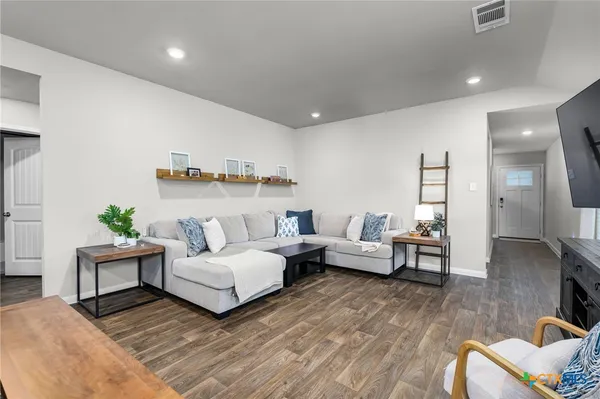 a living room with furniture and wooden floor