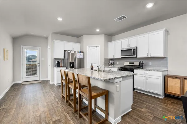 a kitchen with appliances a sink a counter top space and cabinets