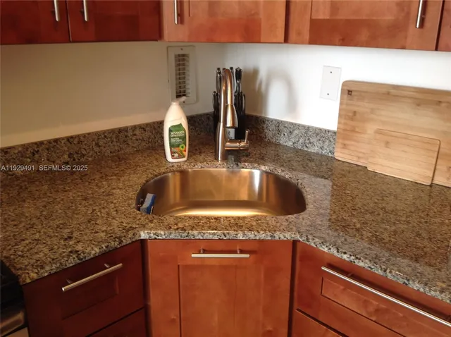a kitchen with granite countertop a sink and a stove
