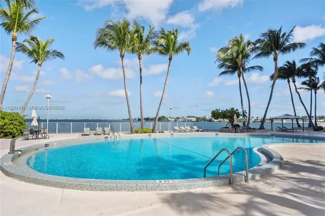a row of palm trees and swimming pool in the patio