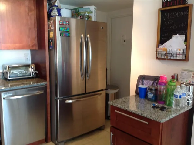 a kitchen with stainless steel appliances granite countertop a refrigerator and a stove