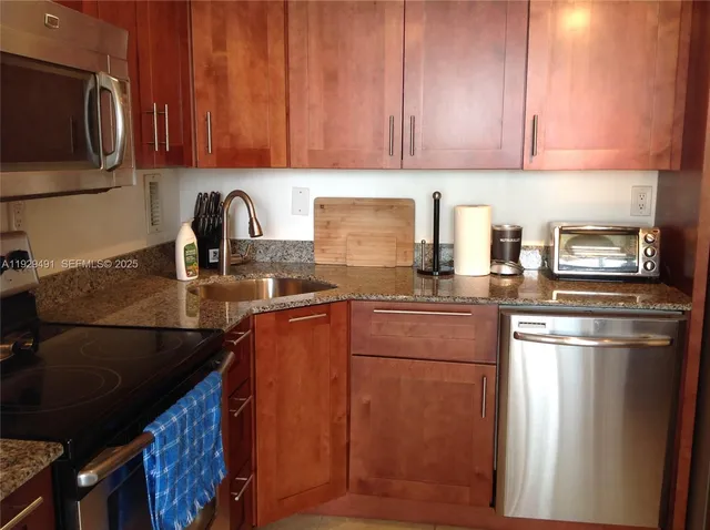 a kitchen with granite countertop stainless steel appliances and wooden cabinets