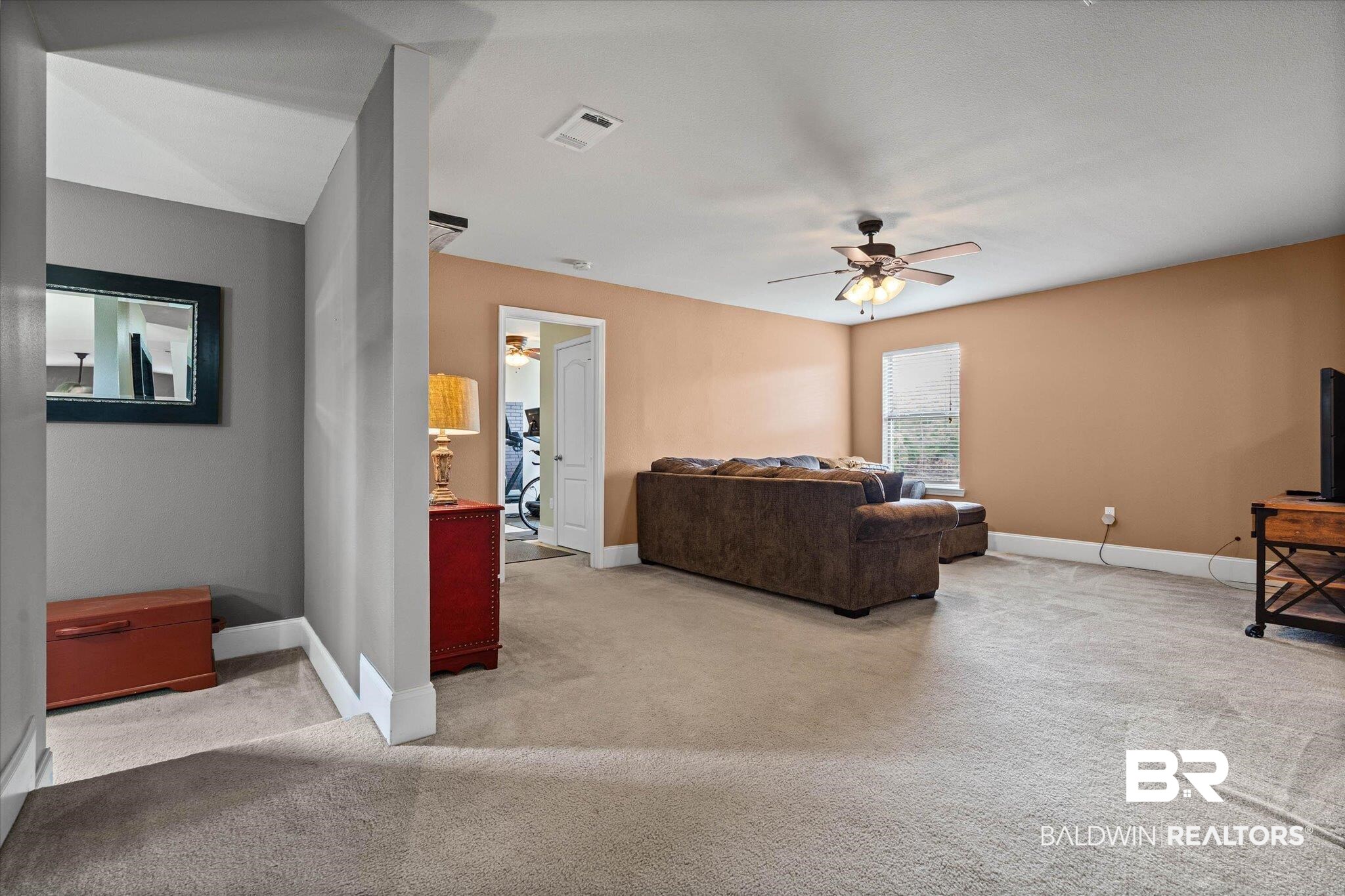 585 Sheffield Avenue Foley, AL 36535 - Photo 17 of 45 Spacious carpeted room featuring a ceiling fan with integrated lighting, a single window, and a doorway leading to another area