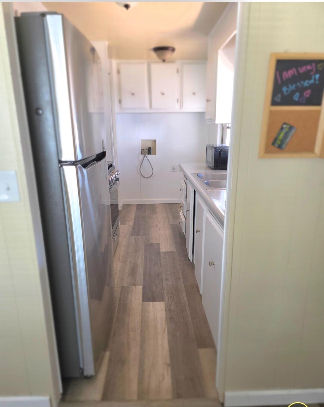 12344-26 Mile Road, Unit 32 Oakdale, CA 95219 - Photo 8 of 22 a kitchen with a refrigerator a stove top oven and a sink