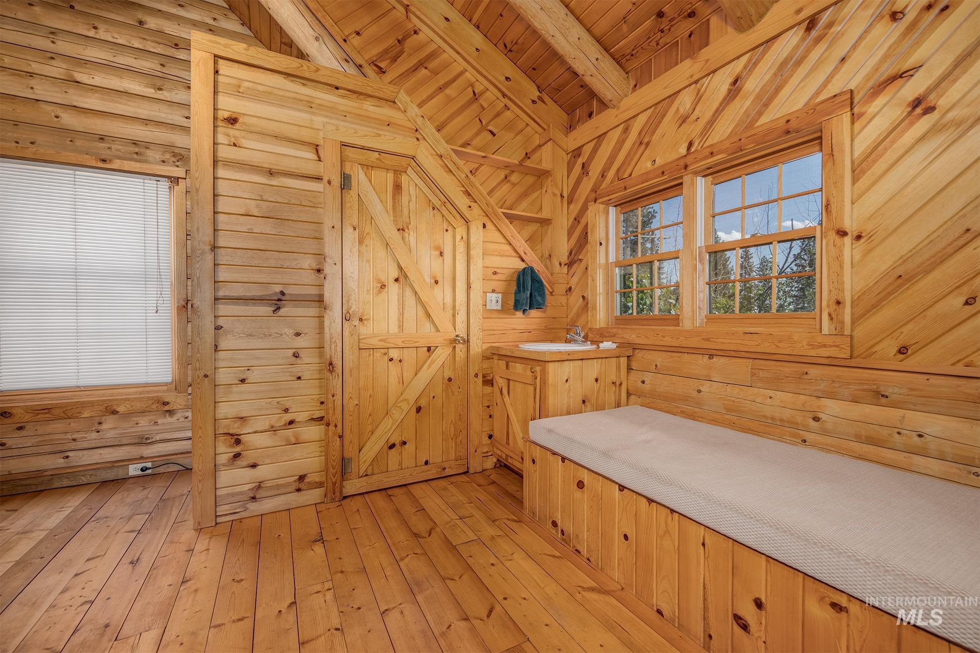 2150 Seid Creek Road Cambridge, ID 83610 - Photo 43 of 50 Pine wood-paneled interior featuring a built-in bench, two double-hung windows, a built-in sink cabinet, and a solid wood door