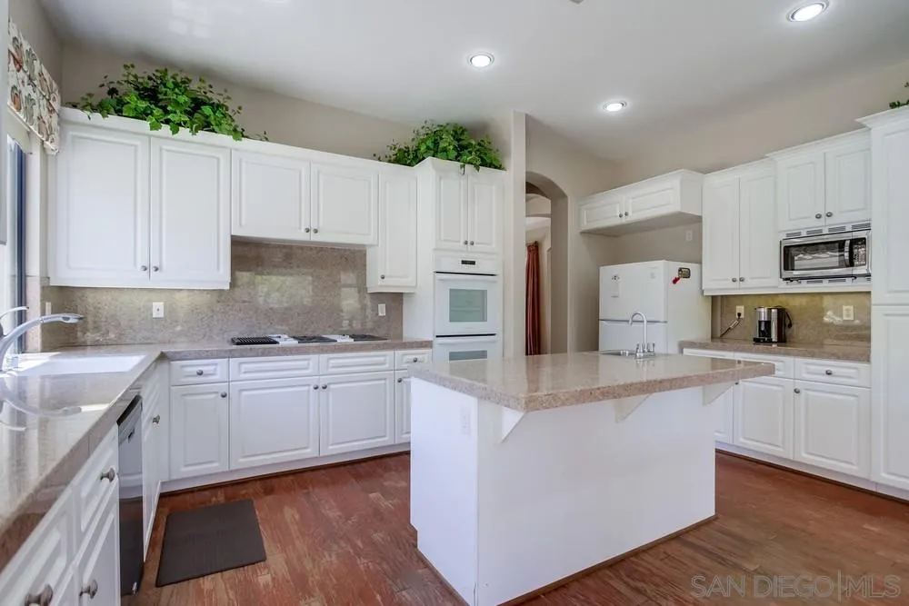 3605-7 Logwood Place Fallbrook, CA 92028 - Photo 35 of 74 a large kitchen with cabinets appliances and wooden floor
