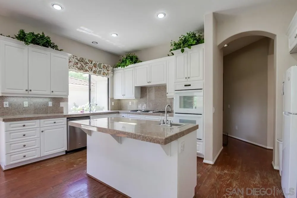 3605-7 Logwood Place Fallbrook, CA 92028 - Photo 36 of 74 a kitchen with kitchen island granite countertop a sink stove and cabinets