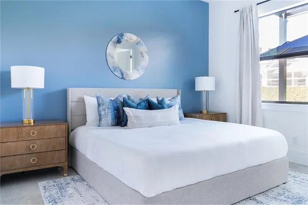 a bedroom with a bed and a painting on the wall