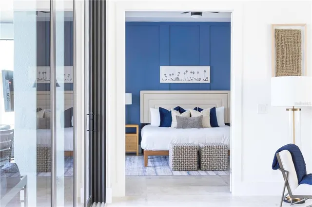 a picture of a bedroom with a bed and a table with potted plant