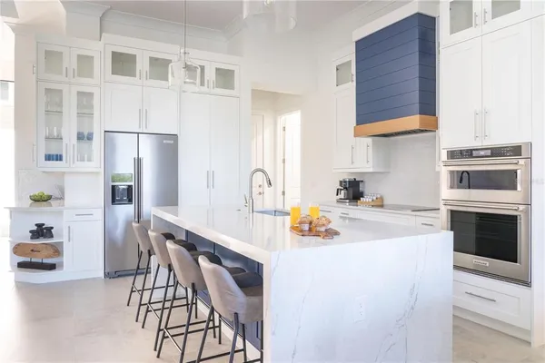 a kitchen with a white cabinets and chairs