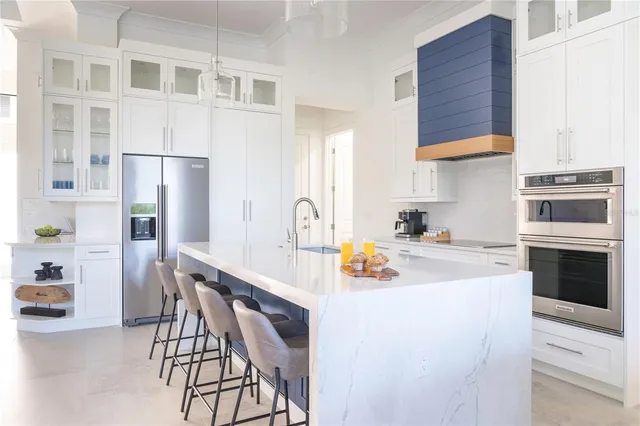a kitchen with a white cabinets and chairs