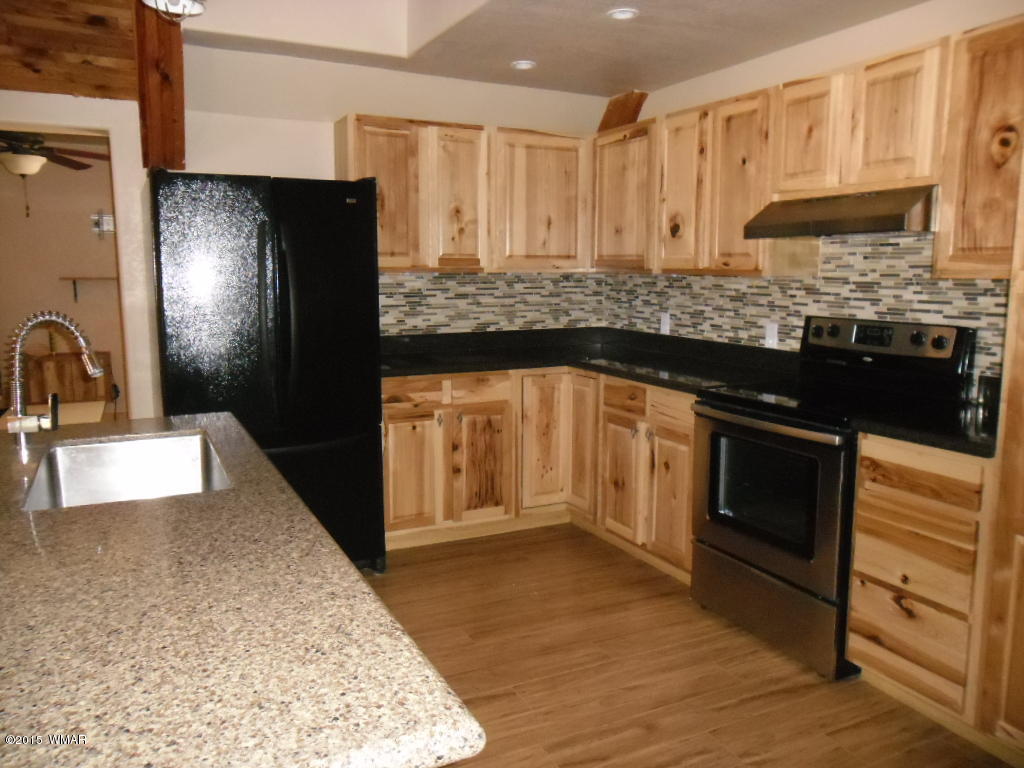 3463 Quail Run Road Overgaard, AZ 85933 - Photo 17 of 37 a kitchen with stainless steel appliances granite countertop a stove a sink and a refrigerator