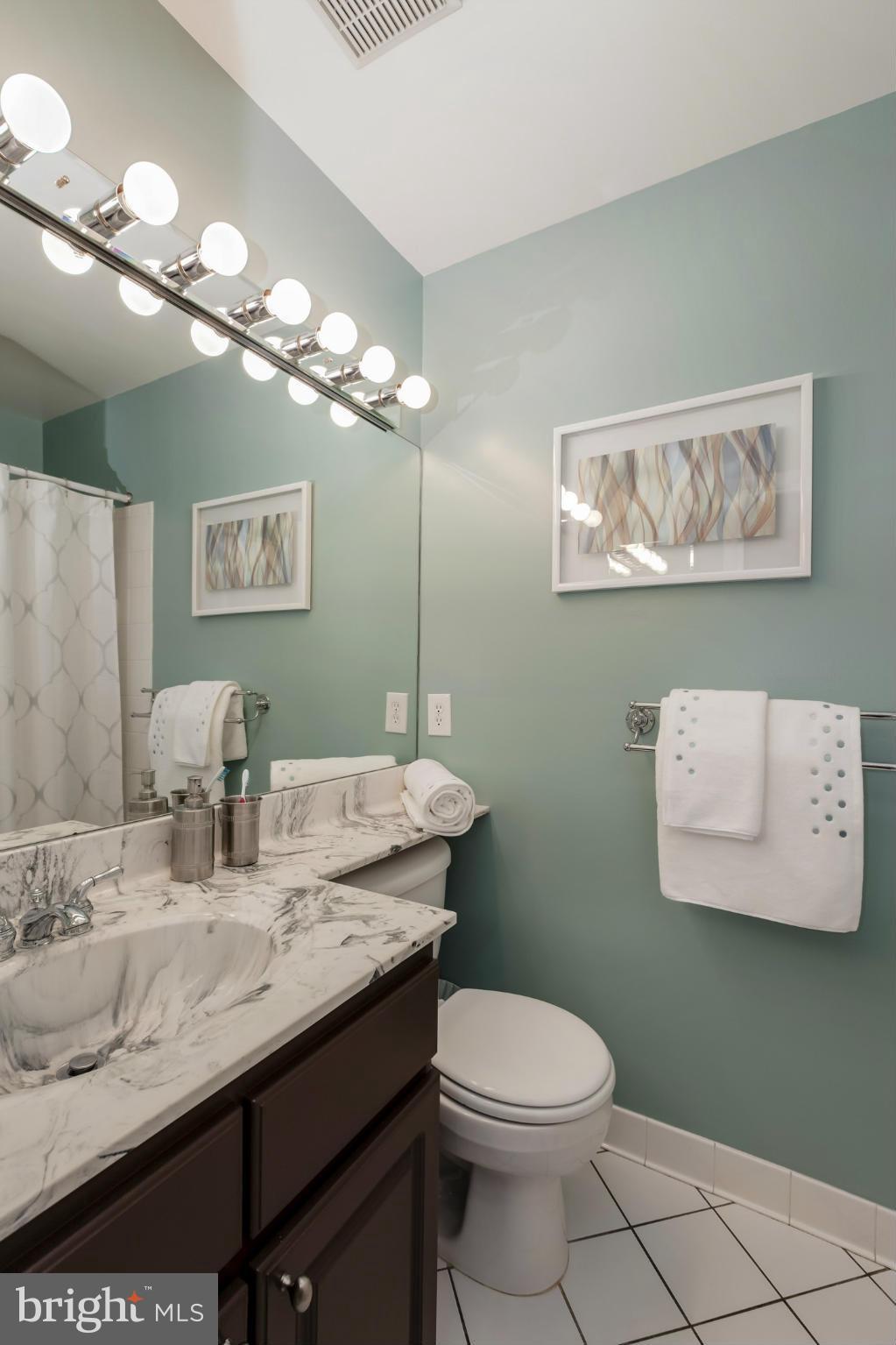 1233 Portner Road Alexandria, VA 22314 - Photo 24 of 29 a bathroom with a granite countertop toilet a sink and a mirror