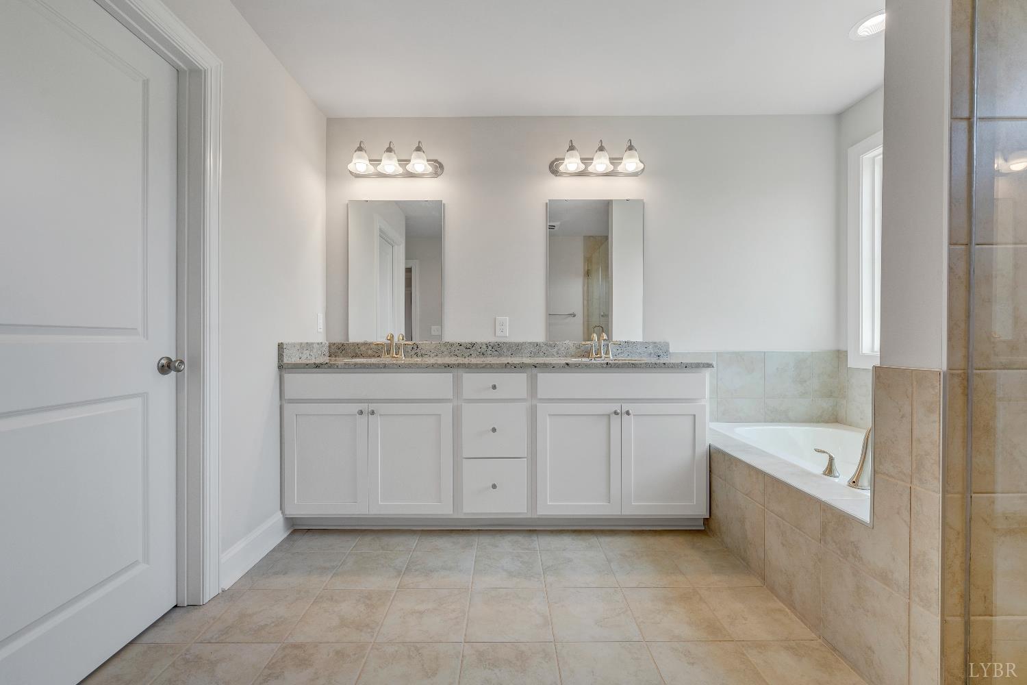 23 Elk Crk Road Forest, VA 24551 - Photo 13 of 22 a spacious bathroom with a granite countertop double vanity sink a mirror and a bathtub