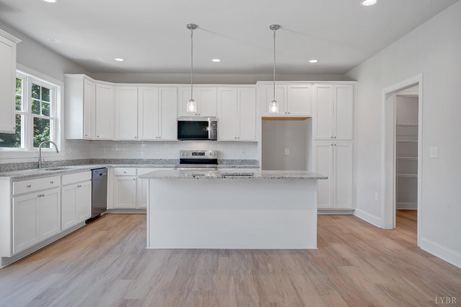 23 Elk Crk Road Forest, VA 24551 - Photo 7 of 22 a kitchen with kitchen island granite countertop a sink cabinets and wooden floor