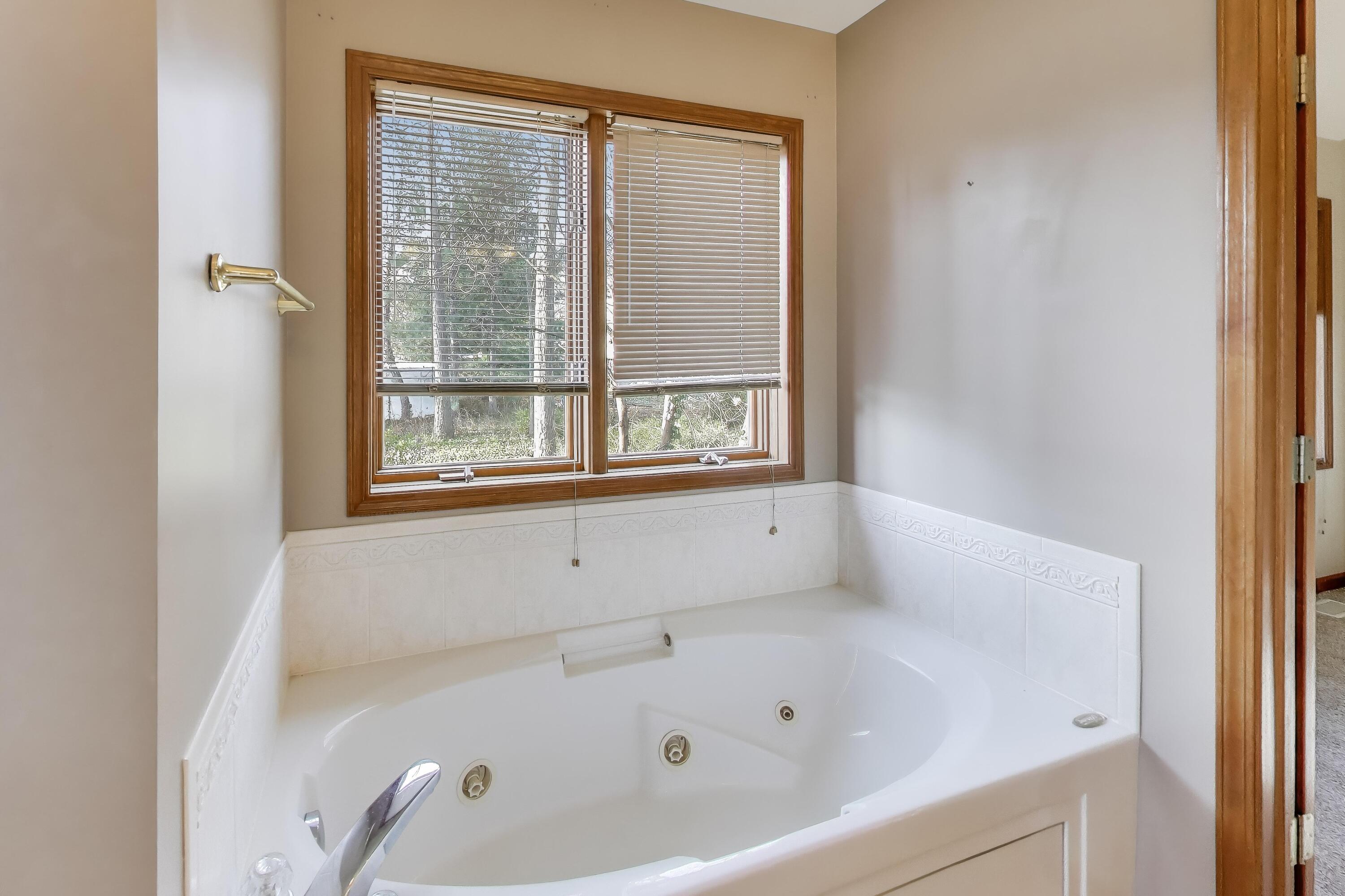1642 Commodore Lane Chesterton, IN 46304 - Photo 17 of 34 a white bath tub sitting in a bathroom next to a window