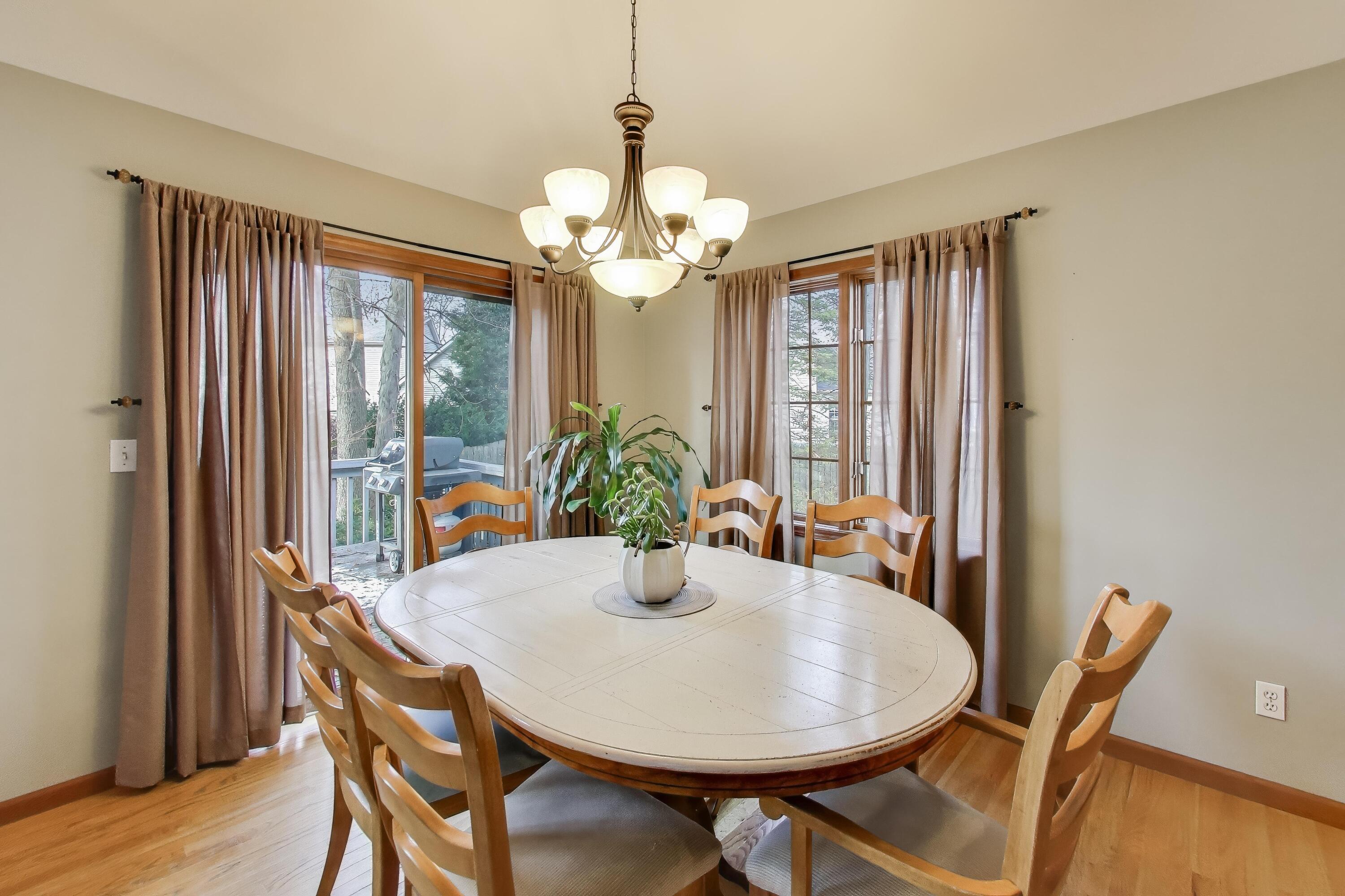 1642 Commodore Lane Chesterton, IN 46304 - Photo 7 of 34 a dining room with furniture potted plants and wooden floor