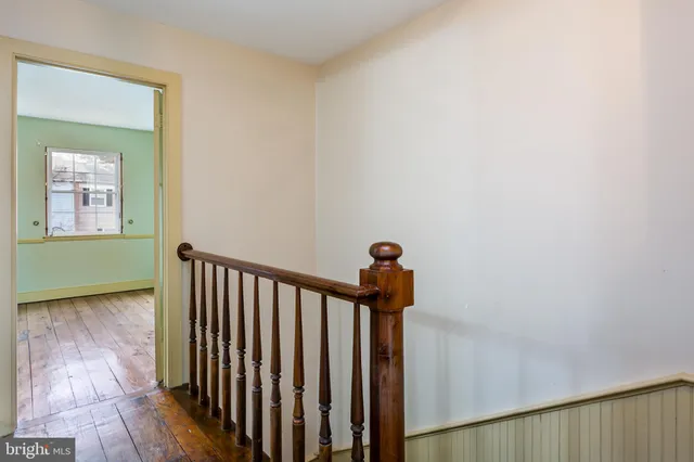 a view of a hallway with a window and wooden floor