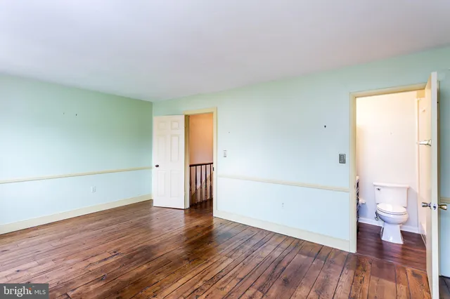 a view of empty room with wooden floor and window