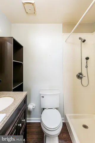 a bathroom with a granite countertop sink toilet and shower