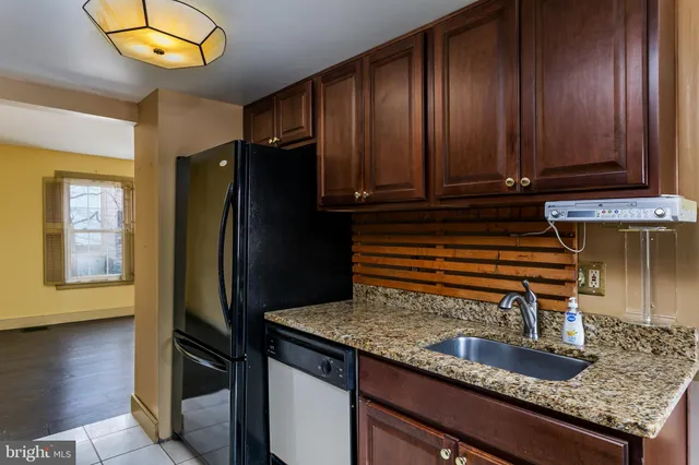 a kitchen with granite countertop a refrigerator a stove and a sink
