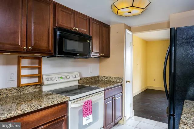 a kitchen with stainless steel appliances granite countertop a stove a microwave and a sink