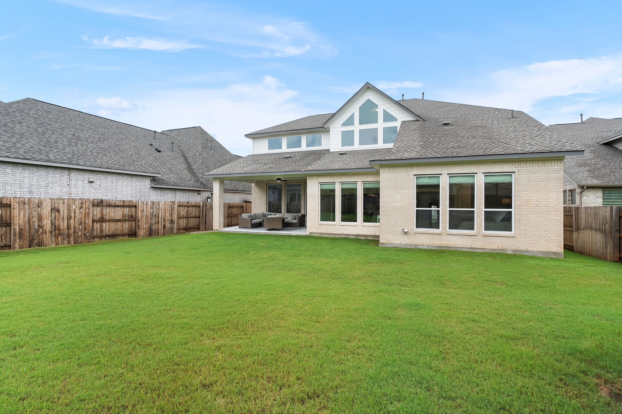 515 Watershield Cove Georgetown, TX 78633 - Photo 35 of 40 A pristine lawn stretches towards a modern residence with an inviting covered patio, ideal for outdoor leisure.