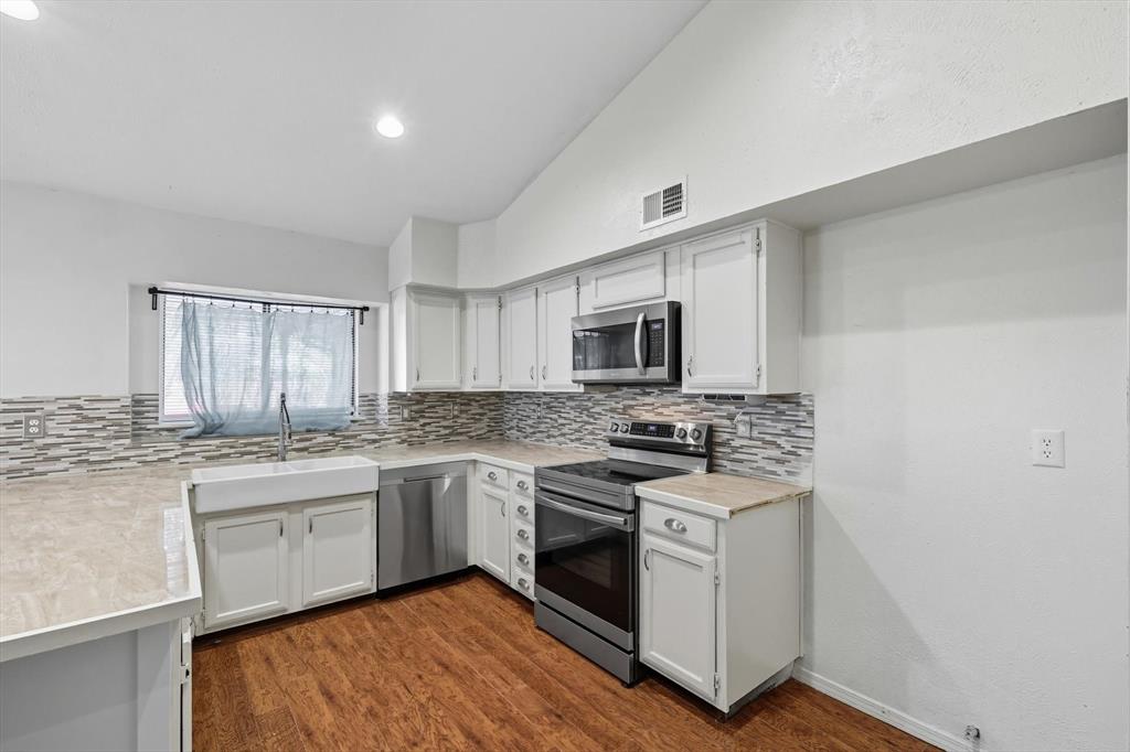 9101 Denver Street Rowlett, TX 75088 - Photo 13 of 40 a kitchen with stainless steel appliances granite countertop a stove and a sink