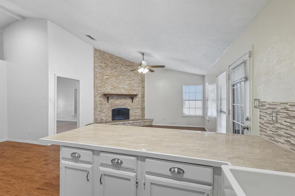 9101 Denver Street Rowlett, TX 75088 - Photo 15 of 40 a view of a kitchen with cabinets and a fireplace
