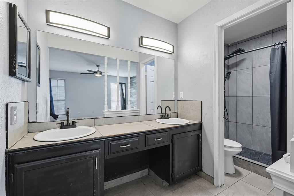 9101 Denver Street Rowlett, TX 75088 - Photo 25 of 40 a bathroom with a double vanity sink toilet and shower