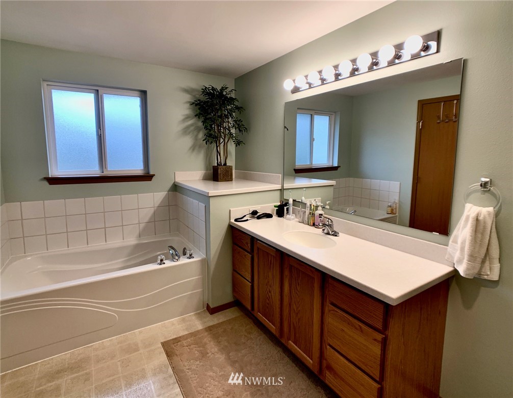 8306 173rd Avenue Southwest Rochester, WA 98579 - Photo 11 of 40 a bathroom with a tub sink and mirror