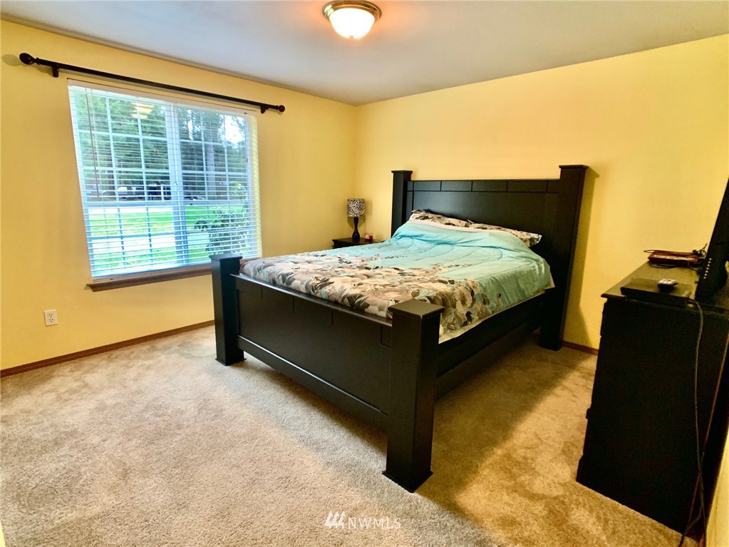 8306 173rd Avenue Southwest Rochester, WA 98579 - Photo 14 of 40 a bedroom with a bed and wooden floor