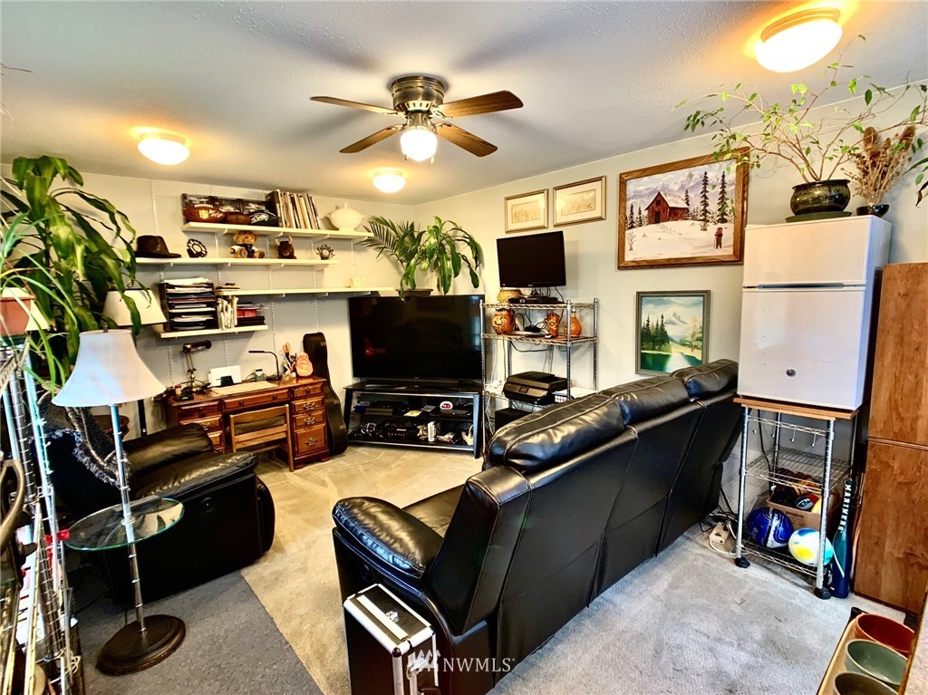 8306 173rd Avenue Southwest Rochester, WA 98579 - Photo 30 of 40 a living room with furniture a flat screen tv and a fireplace