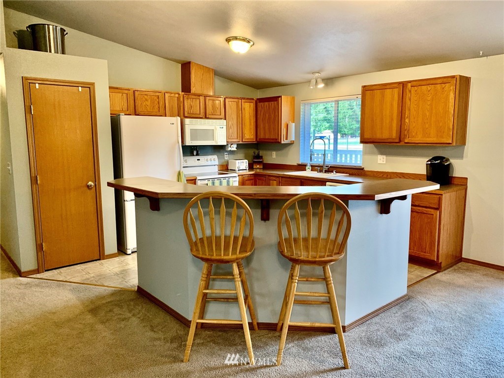 8306 173rd Avenue Southwest Rochester, WA 98579 - Photo 5 of 40 a kitchen with stainless steel appliances granite countertop a sink a stove a refrigerator a dining table and chairs