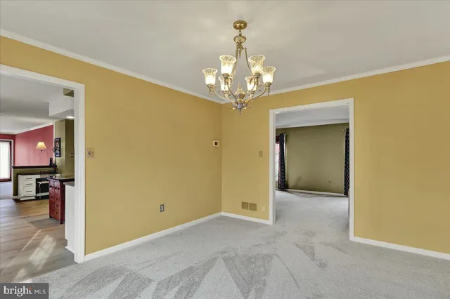a view of a livingroom with a chandelier furniture and windows