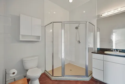 a bathroom with a toilet a sink and glass door