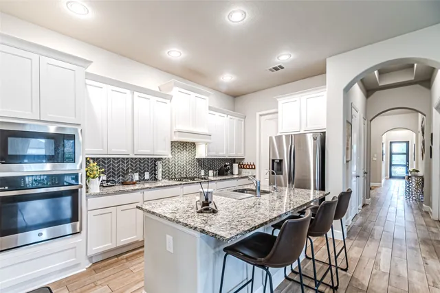 a kitchen with a refrigerator sink and stove