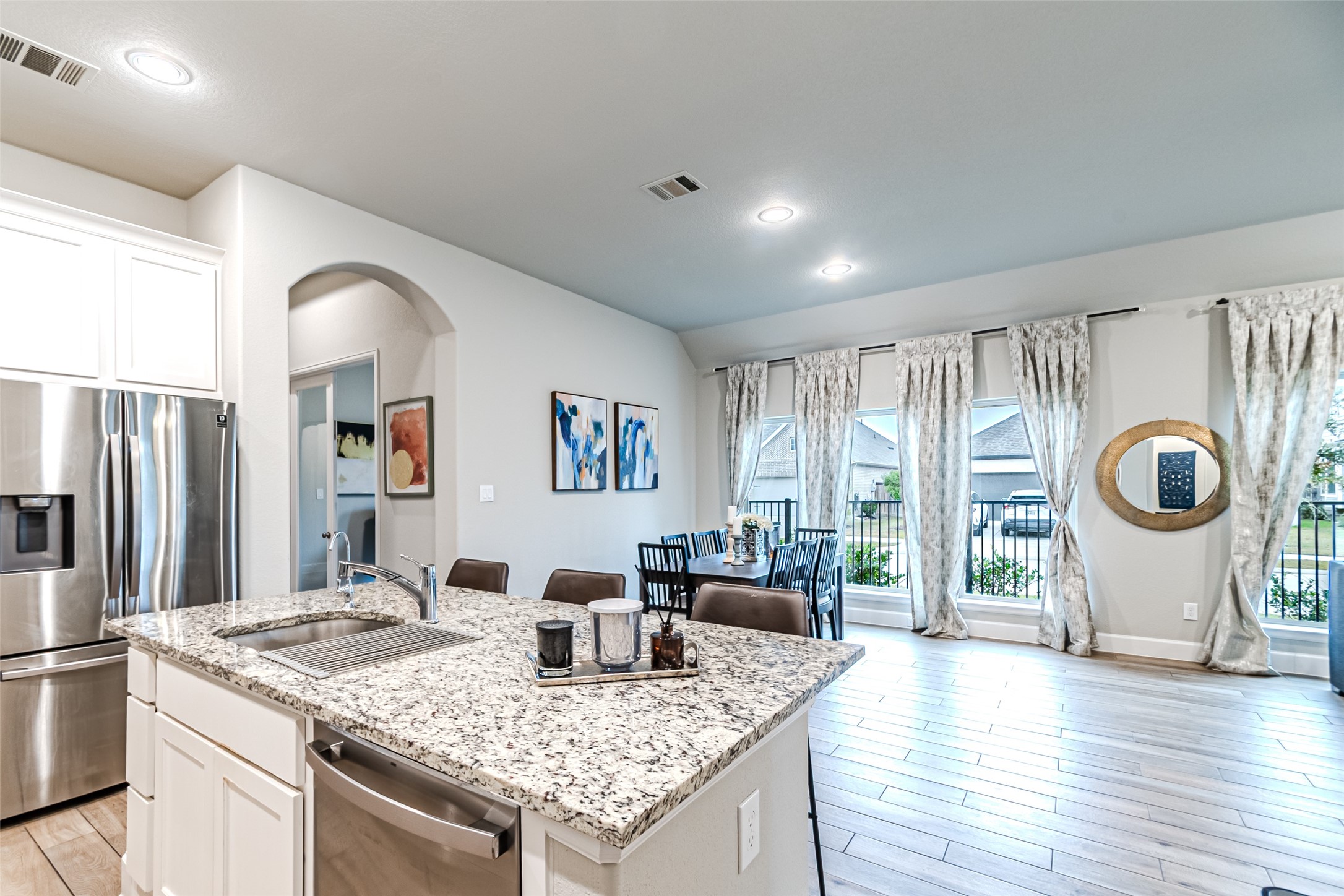15022 Concho River Way Cypress, TX 77433 - Photo 27 of 50 a hall with kitchen island granite countertop wooden floor a large window and a sink