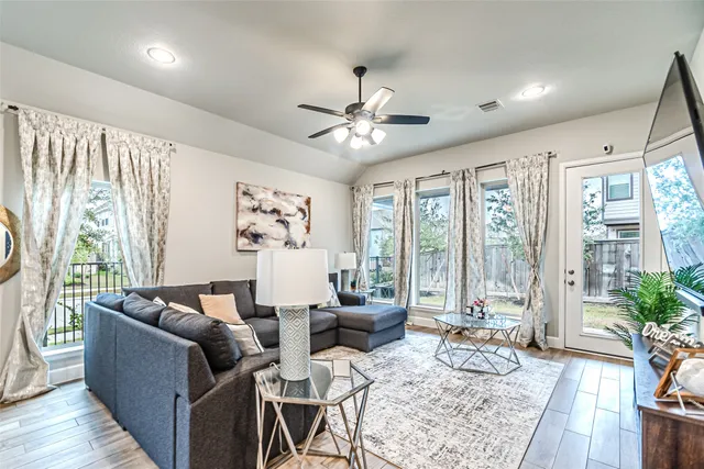 a living room with furniture and a flat screen tv with wooden floor