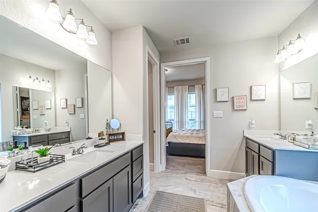 a bathroom with a double vanity sink mirror and toilet