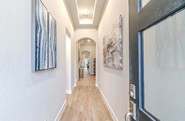 a view of a hallway with wooden floor and staircase