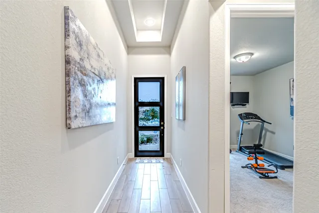 a view of a hallway to a livingroom with a workspace