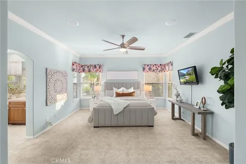 a bedroom with a large bed and a chandelier